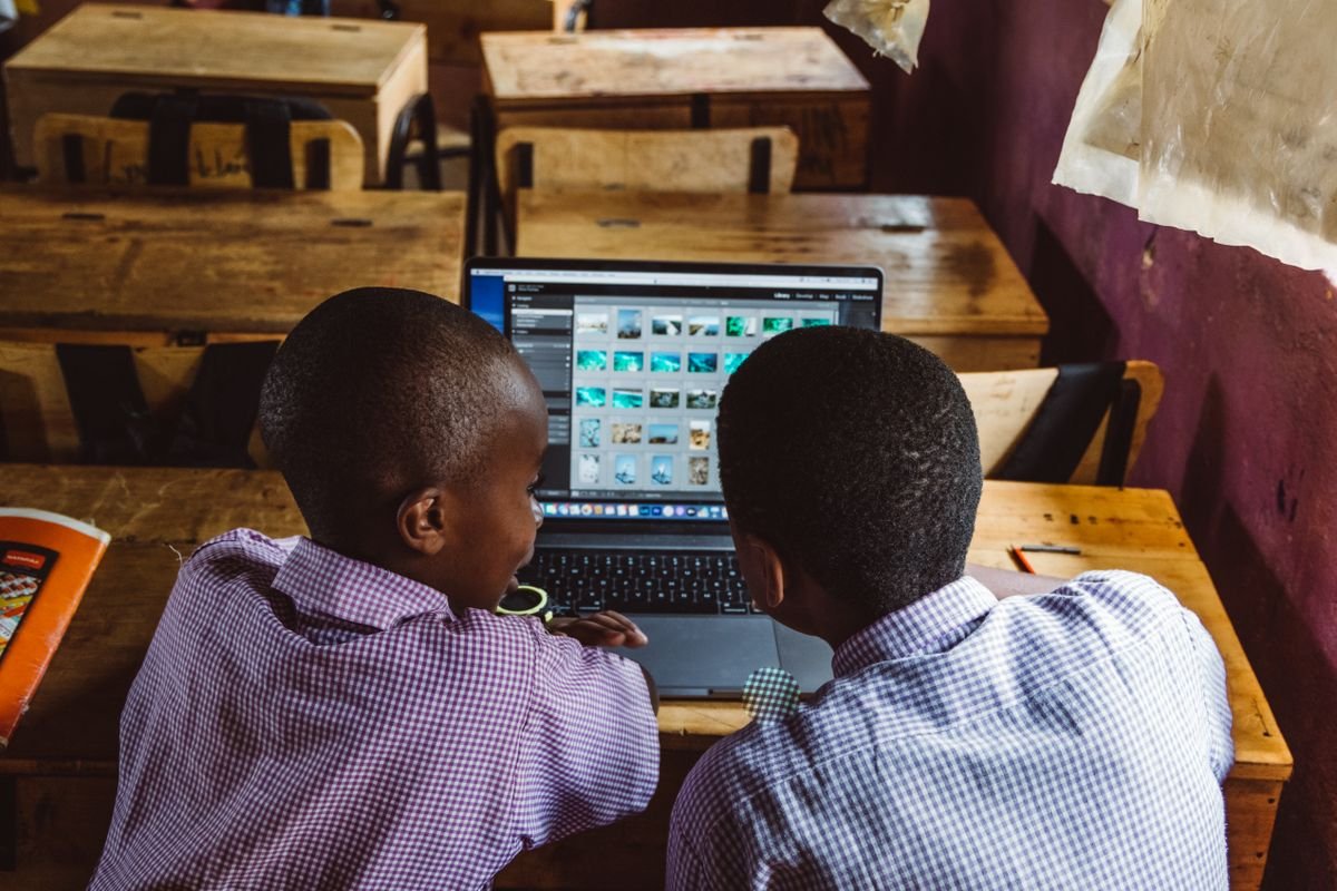 Two students working together on a laptop in class